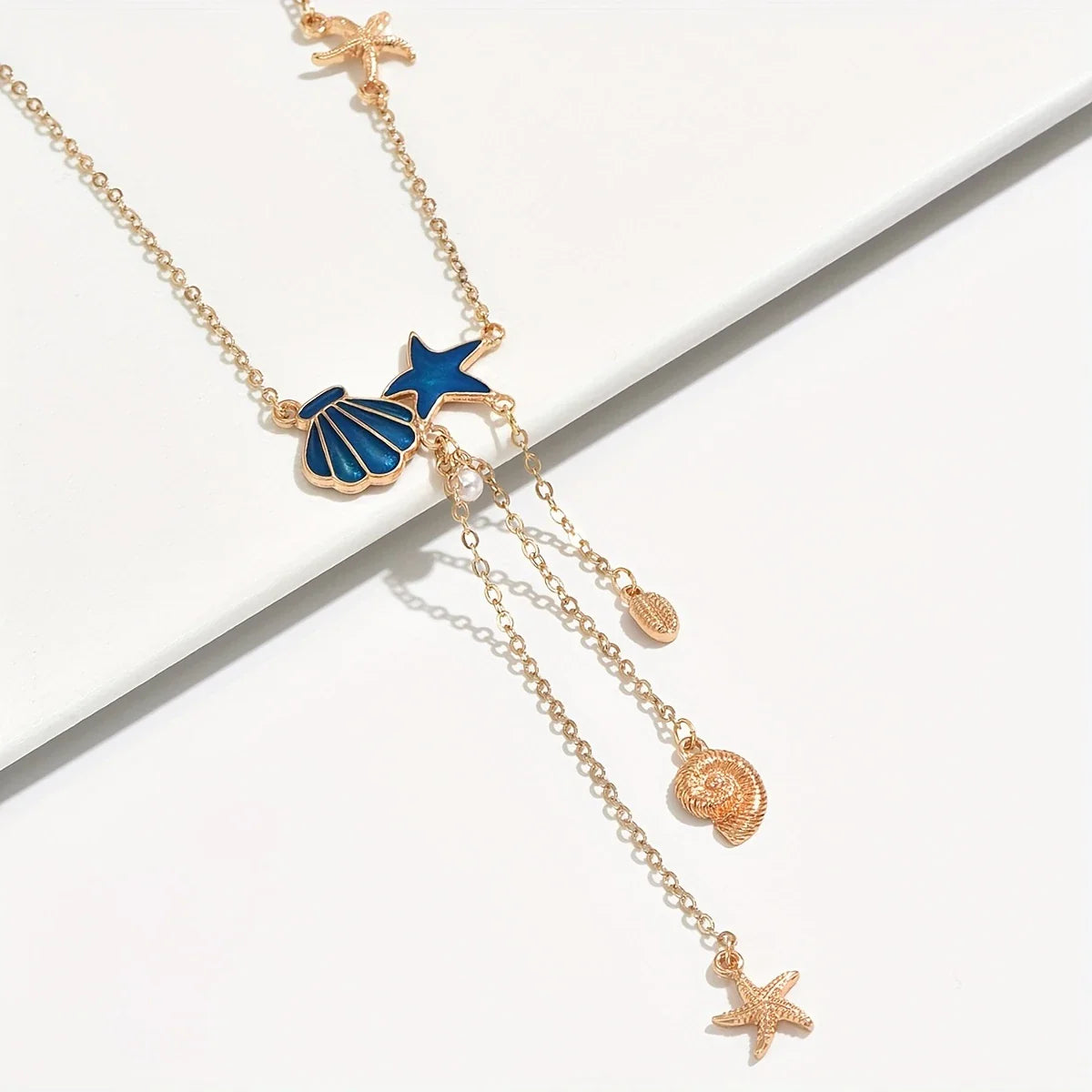 Elegante goldene Halskette mit Stern und blauer Muschel