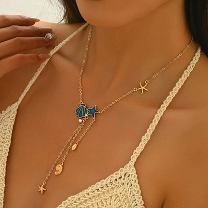 Elegante goldene Halskette mit Stern und blauer Muschel